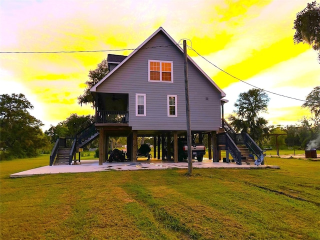 back house at dusk with a carport and a yard