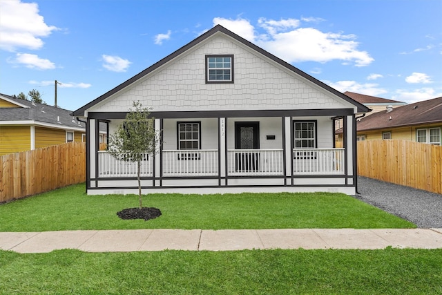 bungalow-style house featuring covered porch, a front yard, and fence private yard