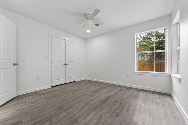 unfurnished bedroom featuring a closet, hardwood / wood-style flooring, and ceiling fan