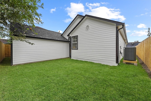 back of house featuring a lawn and cooling unit