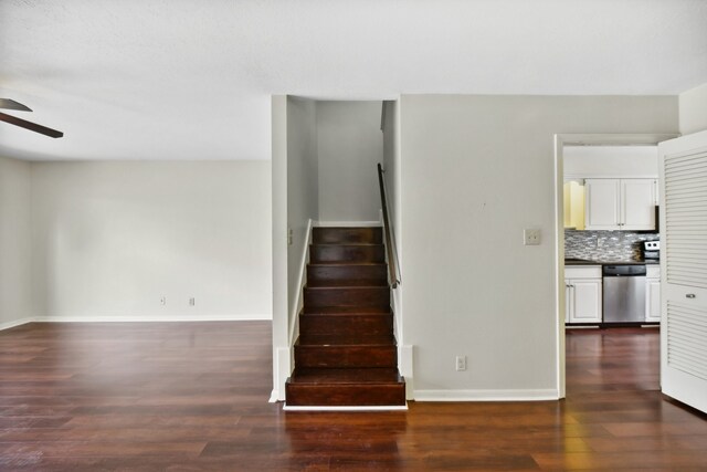 stairway with wood-type flooring and ceiling fan