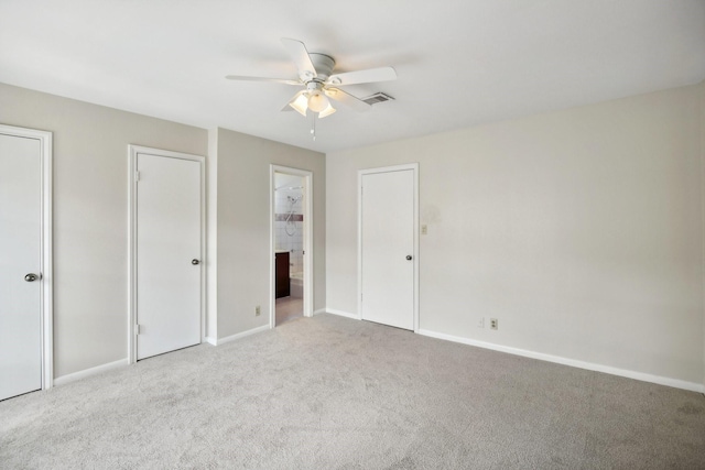 unfurnished bedroom with light carpet, ensuite bath, and ceiling fan