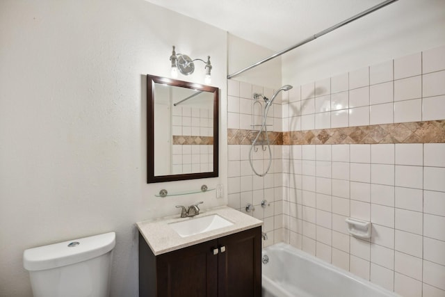 full bathroom with vanity, tiled shower / bath combo, and toilet