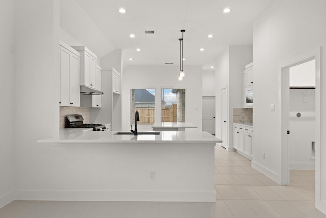 kitchen with white cabinets, decorative light fixtures, stainless steel range oven, and tasteful backsplash