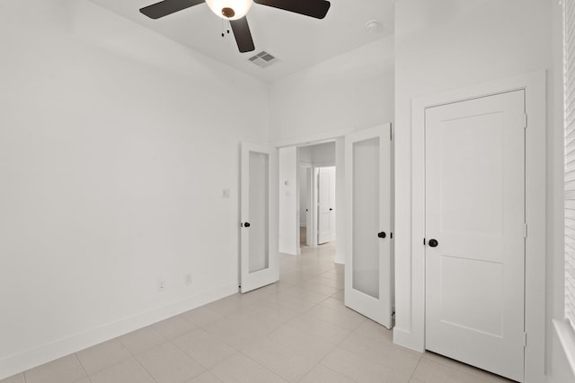 unfurnished bedroom featuring ceiling fan, french doors, and light tile patterned floors