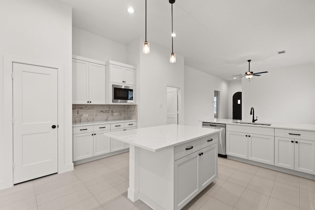 kitchen featuring ceiling fan, built in microwave, sink, dishwasher, and hanging light fixtures