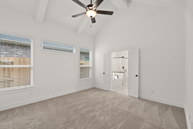 unfurnished bedroom featuring ensuite bath, ceiling fan, beamed ceiling, high vaulted ceiling, and light carpet