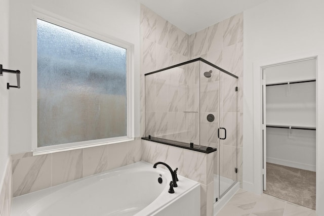 bathroom featuring shower with separate bathtub