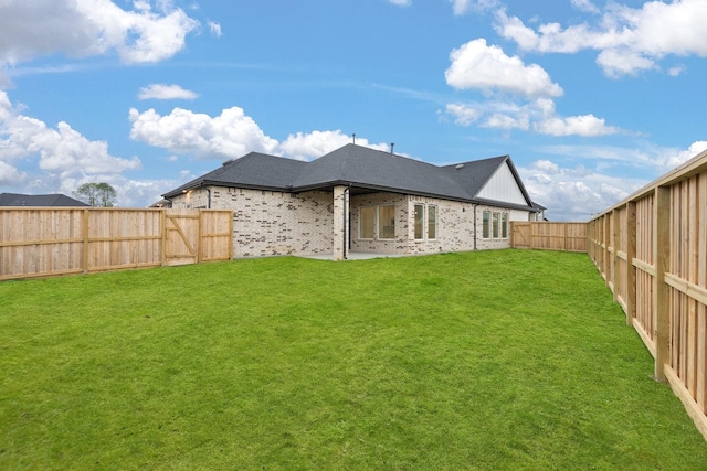 rear view of house featuring a yard and a patio area