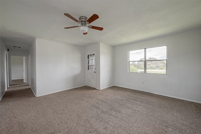 carpeted spare room featuring ceiling fan and a textured ceiling