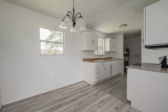 kitchen featuring a wealth of natural light, a notable chandelier, white cabinets, and light wood-type flooring