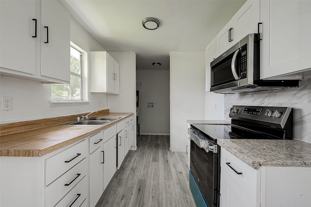 kitchen with stainless steel appliances, sink, light hardwood / wood-style floors, and white cabinets