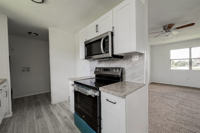 kitchen featuring stainless steel appliances, tasteful backsplash, ceiling fan, light colored carpet, and white cabinets