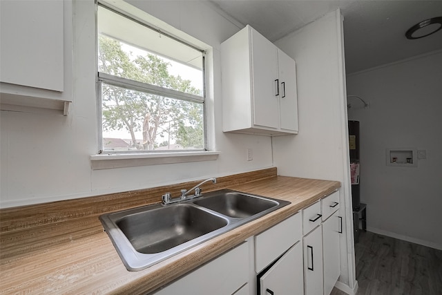 kitchen featuring white cabinetry, a wealth of natural light, sink, and wood-type flooring