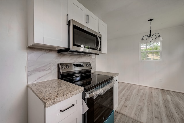 kitchen with light hardwood / wood-style flooring, tasteful backsplash, pendant lighting, white cabinets, and appliances with stainless steel finishes