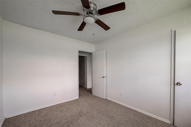 carpeted spare room with a textured ceiling and ceiling fan