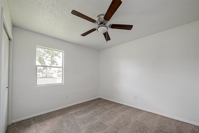 carpeted spare room featuring a textured ceiling and ceiling fan