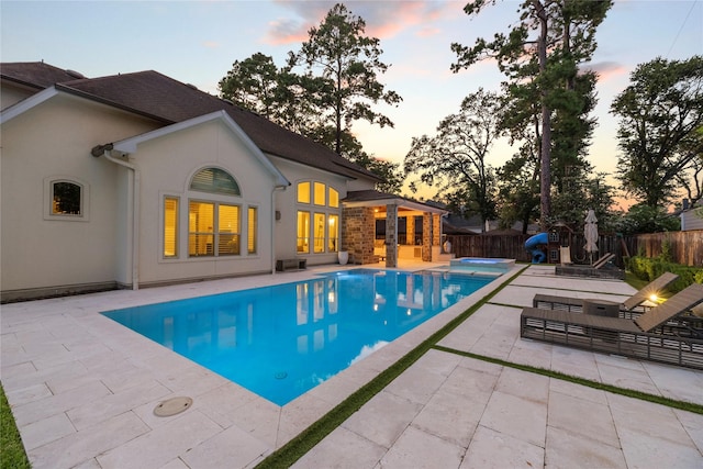 pool at dusk with a patio