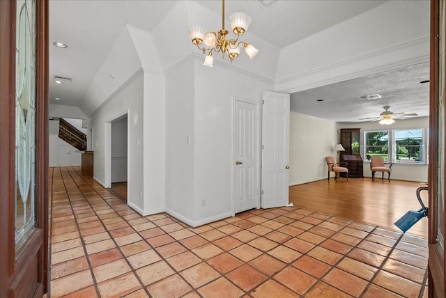 entrance foyer with light tile patterned floors, baseboards, a textured ceiling, and ceiling fan with notable chandelier