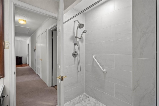 full bath with tiled shower, crown molding, and a textured ceiling