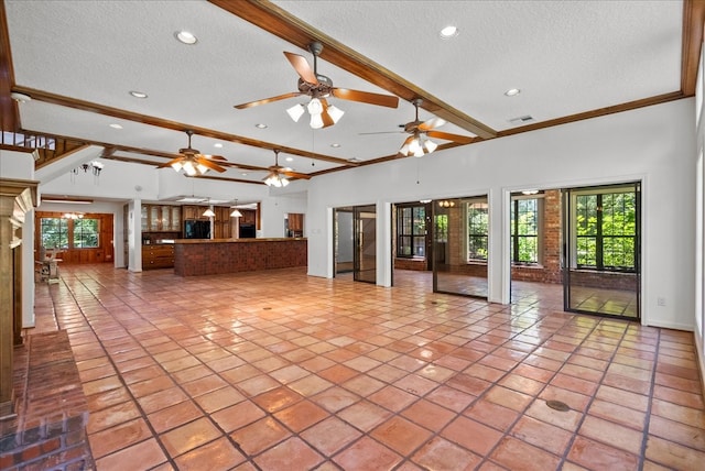 unfurnished living room featuring a wealth of natural light, visible vents, beamed ceiling, and a textured ceiling