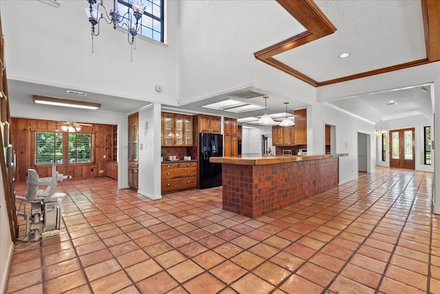 kitchen featuring ceiling fan with notable chandelier, a peninsula, light tile patterned floors, and black fridge with ice dispenser