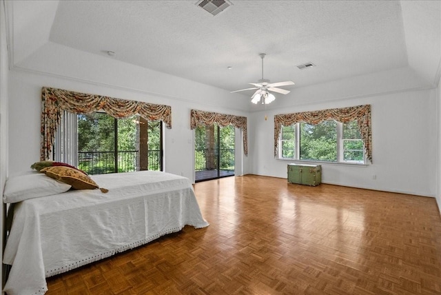 bedroom with access to exterior, multiple windows, visible vents, and a textured ceiling