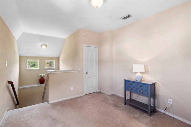 interior space featuring light carpet and lofted ceiling