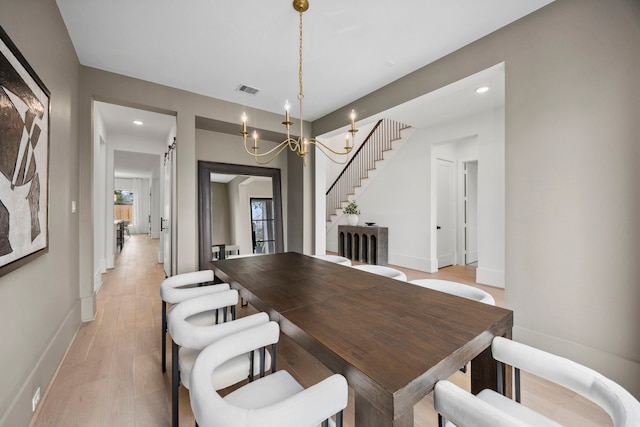 dining room with light wood-style floors, baseboards, stairs, and visible vents