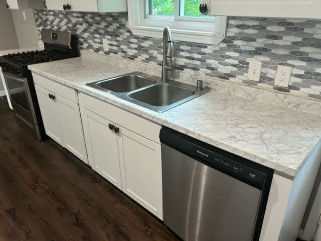 kitchen with stainless steel appliances, dark hardwood / wood-style flooring, backsplash, and white cabinetry