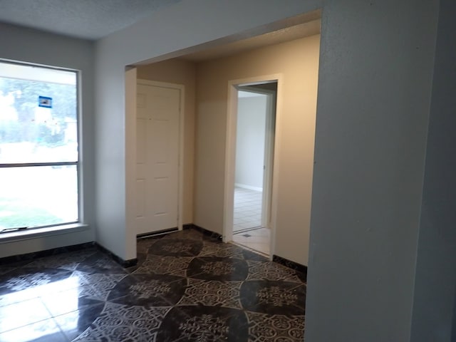 hall featuring dark tile flooring