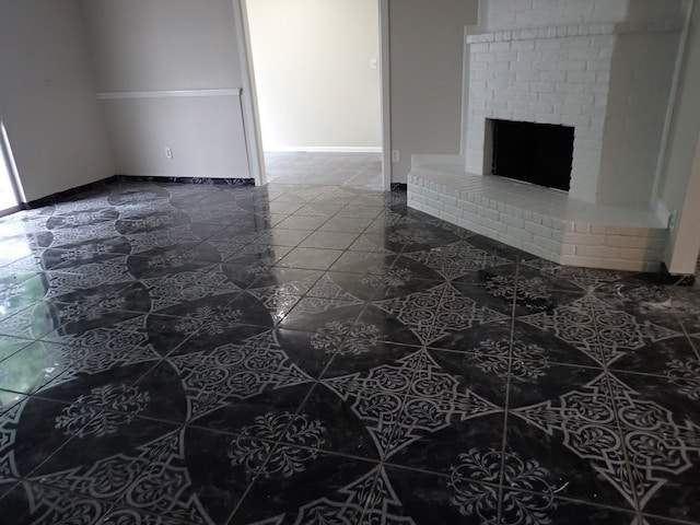 unfurnished living room featuring a brick fireplace and tile flooring