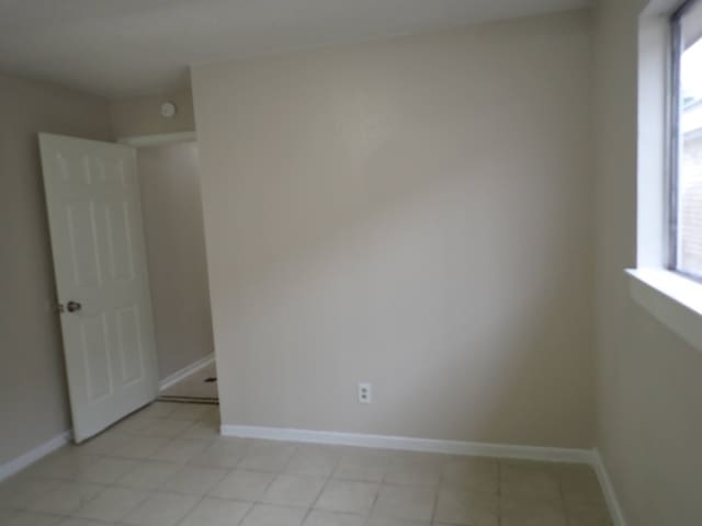 tiled spare room featuring a wealth of natural light