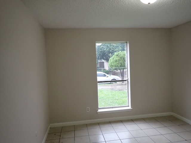 tiled spare room with a textured ceiling