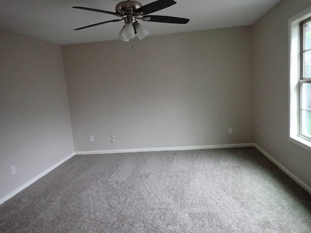 carpeted empty room with a wealth of natural light and ceiling fan