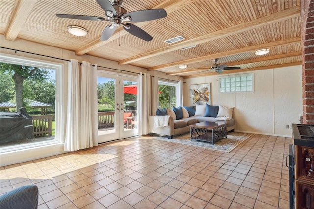 tiled living room featuring beam ceiling, a wealth of natural light, and ceiling fan