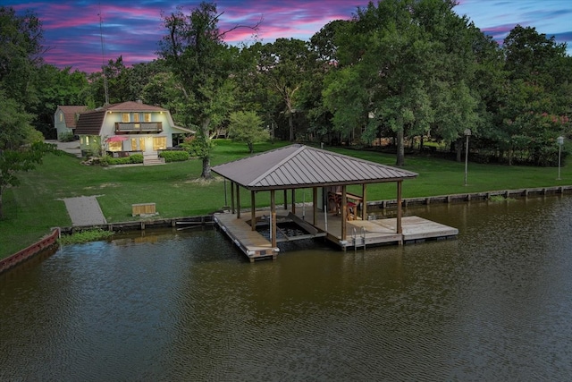 dock area with a lawn and a water view