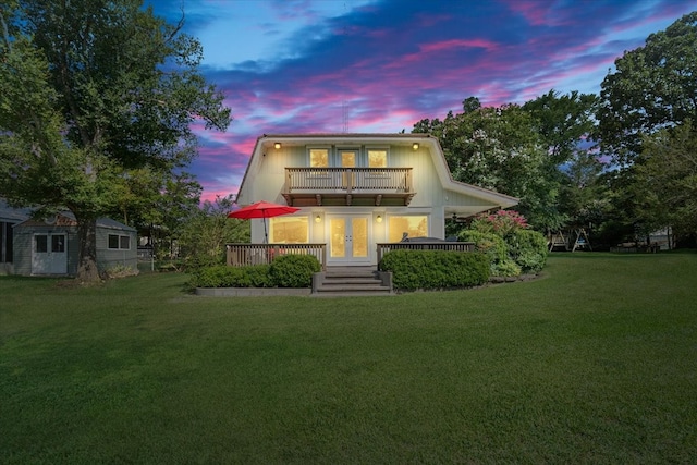 view of property with a balcony and a lawn