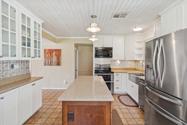 kitchen with appliances with stainless steel finishes, white cabinets, tasteful backsplash, and hanging light fixtures