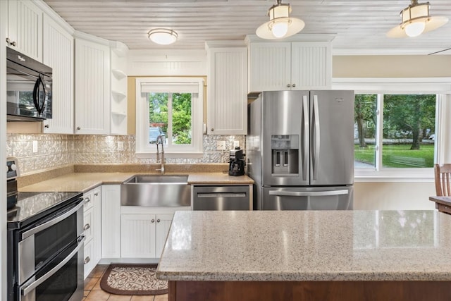 kitchen featuring sink, light stone counters, tasteful backsplash, and appliances with stainless steel finishes