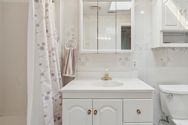 bathroom with tile walls, tasteful backsplash, toilet, and vanity