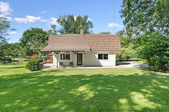 back of house featuring a patio area and a lawn