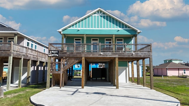 view of front facade featuring a deck, a carport, a front yard, a garage, and covered porch