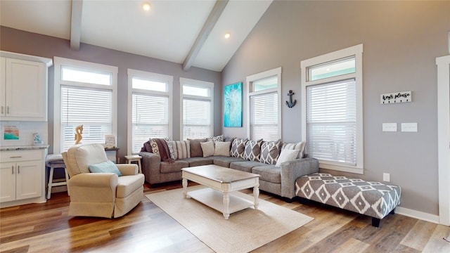 living room featuring beamed ceiling, light wood-type flooring, and high vaulted ceiling