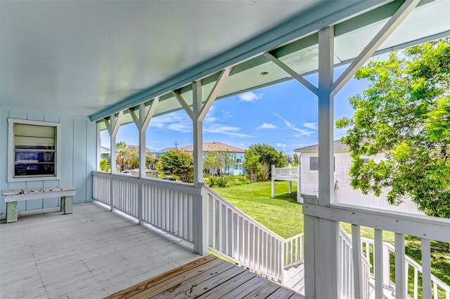 wooden deck featuring a lawn