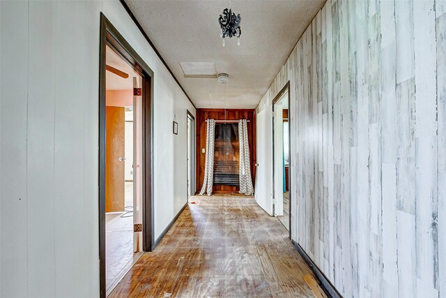 corridor with hardwood / wood-style floors and a textured ceiling