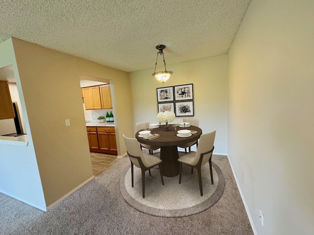 carpeted dining area featuring a textured ceiling