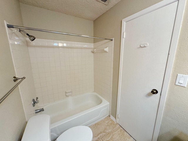 bathroom featuring toilet, bathtub / shower combination, a textured ceiling, and tile patterned floors