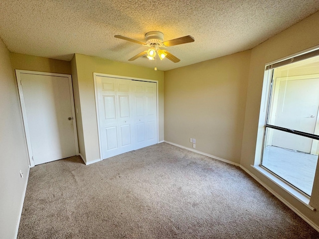 unfurnished bedroom featuring ceiling fan, light colored carpet, and a textured ceiling