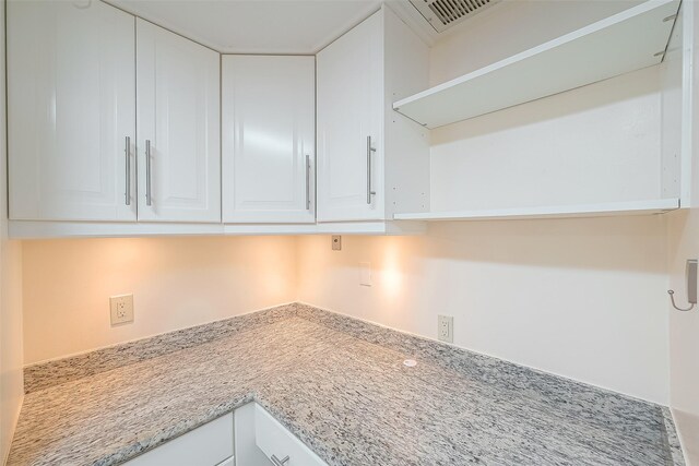 kitchen with light stone counters and white cabinets